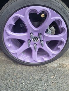 a purple car wheel with hearts on it's spokes and tire hubs