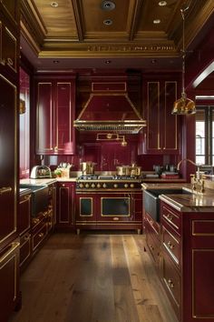 a kitchen with red cabinets and gold trim on the ceiling, along with wooden floors