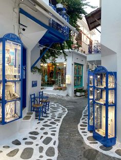 an alley way with blue and white furniture on the sides, in front of a building