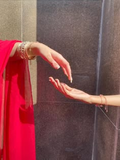 two hands reaching out to each other in front of a shower stall with the curtain pulled back