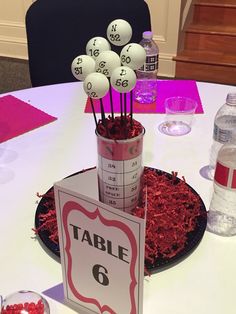 a table that has some balls in it and a sign on the table with numbers