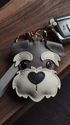 a dog keychain with a cell phone attached to it's back end