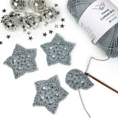 crochet stars and balls of yarn are on the table with scissors, needles and ball of thread