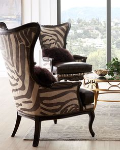 a zebra print chair sits in front of a coffee table with a vase on it