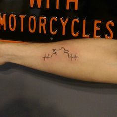 a person with a tattoo on their arm and the words, with motorcycles written below it