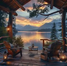 two chairs and a table on a wooden deck overlooking the water at sunset or sunrise