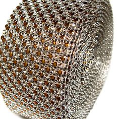 a close up view of a silver and brown beaded tie on a white surface