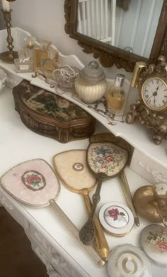 there are many antique items on the counter in this room, including spoons and mirrors