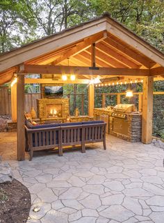 an outdoor kitchen and grill area is lit up at night with candles on the table