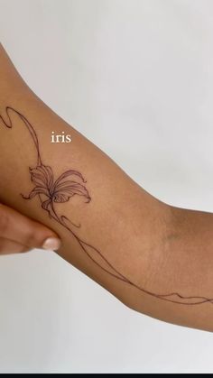 a woman's arm with a flower on it and the words iris written in white ink