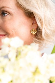 a close up of a person with flowers in the background