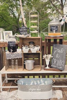 an outdoor buffet table with chalkboard signs and other items on the outside, including drinks