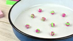 some pink and green candies in a blue bowl