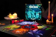 an illuminated board game set up on a table with candles and other items in the background