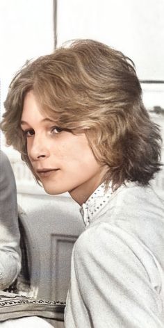 a woman with short hair sitting on a couch