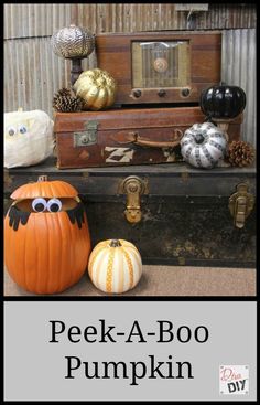 an old trunk with pumpkins and other decorative items on it, along with the words peek - a - boo pumpkin