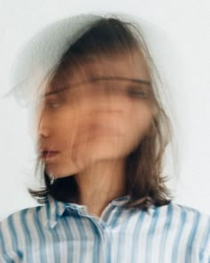 a blurry photo of a woman's face with her hair blowing in the wind