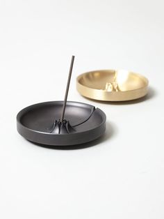 a black and gold incense bowl on a white surface