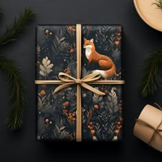 a gift box wrapped in wrapping paper with a fox design on it, surrounded by pine branches