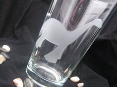 a glass with a cut out of a dog on the bottom and shells around it