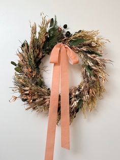 a wreath with a bow hanging on the wall