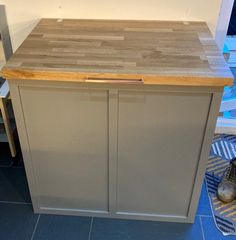 a kitchen island made out of wood and metal with a cutting board on the top