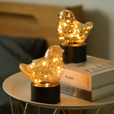 two small lights sitting on top of a table next to books and a book bag