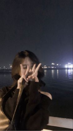 a woman sitting on top of a boat while holding her hands up to the side