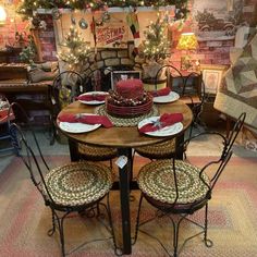 a dining room table set for christmas with plates and napkins on it, surrounded by holiday decorations