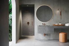 a bathroom with a large round mirror above the sink