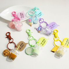 several keychains with different designs on them sitting next to a white plate and spoon