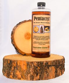 a bottle of pentacry sitting on top of a piece of tree trunk