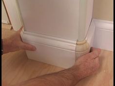 a man is holding the bottom panel of a refrigerator