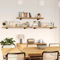 a dining room table with chairs and bookshelves above it, along with shelves on the wall