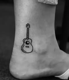 a small guitar tattoo on the ankle