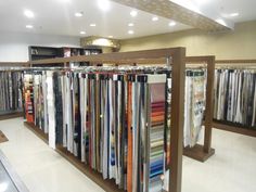 rows of folded shirts are on display in a clothing store, with lights above them