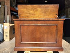 an old wooden box sitting on top of a pallet in a room filled with boxes