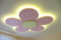 the ceiling is decorated with pink and white flowers on it's petals, which are lit up by leds