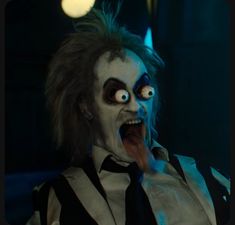 a creepy clown with his mouth open and tongue out