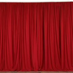 a red curtain is open in front of a white wall