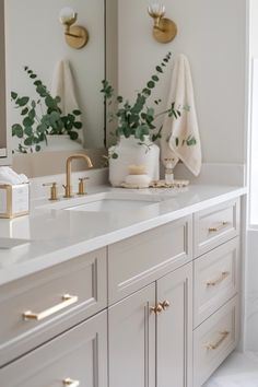 a bathroom with two sinks and gold faucets on the counter top next to mirrors