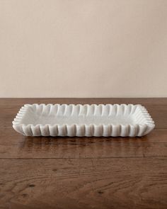 a white ceramic dish sitting on top of a wooden table