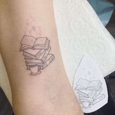 a tattoo on the arm of a woman with books