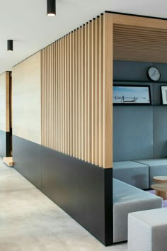 the inside of a modern office building with wooden partitions on the wall and couches