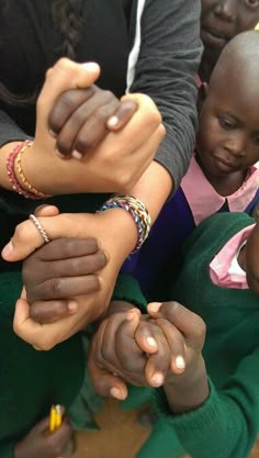 several people are holding hands together in a circle, with one woman's hand on top of the other