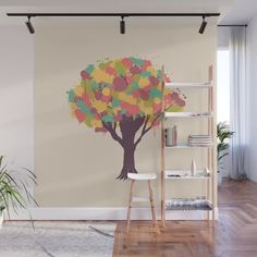 a tree with colorful leaves painted on it in a living room wall decal design