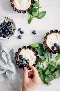 blueberry cheesecakes with whipped cream and fresh mint sprigs on the side