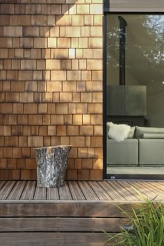 a wooden deck with a planter on it and a couch in the back ground