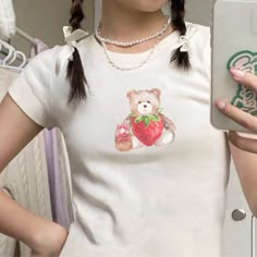 "🌟 Thank you for stopping by GirlyThreadsCo! This strawberry teddy bear baby tee is made to order just for you! This is the perfect tee for coquette lovers, trendy girlycore fans, or is great for everyday wear! 👕 PRODUCT & DESCRIPTION 🛑 PLEASE NOTE: The sizing of this baby tee is not the same as standard US Women's sizes. We recommend you size up 1-2 sizes to achieve the same fitted look as our model photo. This shirt does run small around the arms, shoulder, and bust area and we recommend sizing up. Our Gildan Youth 5000B t-shirts are pure comfort and 100% cotton. Please be sure to check the sizing chart to choose the right size for your preferred fit. Lay your favorite baby tee at home flat and measure armpit to armpit to compare to the size chart in the photos. Also keep in mind that Cute White T-shirt With Bear Design, White Bear Design Short Sleeve Tops, White Short Sleeve Top With Bear Design, Cute Short Sleeve T-shirt With Bear Print, Cute Bear Print Short Sleeve Tops, Cute Bear Print Top With Short Sleeves, Cute Cotton T-shirt With Bear Design, Cute Short Sleeve Top With Bear Print, Cute Short Sleeve Tops With Bear Print