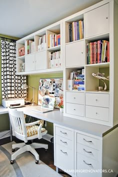 a white desk sitting under a window next to a book shelf